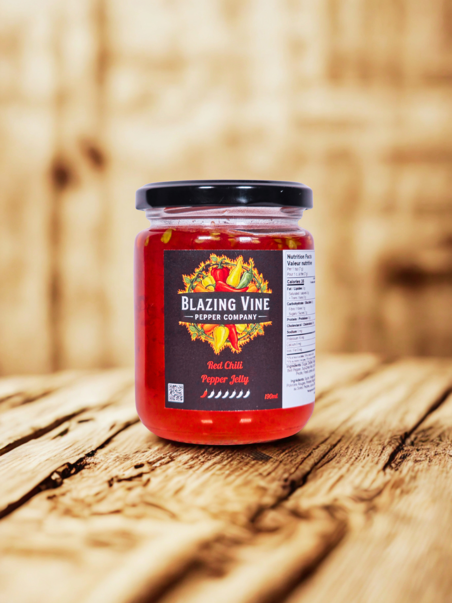 Blazing Vine Red Chili Pepper Jelly — vibrant red jelly in a glass jar on a rustic wood surface